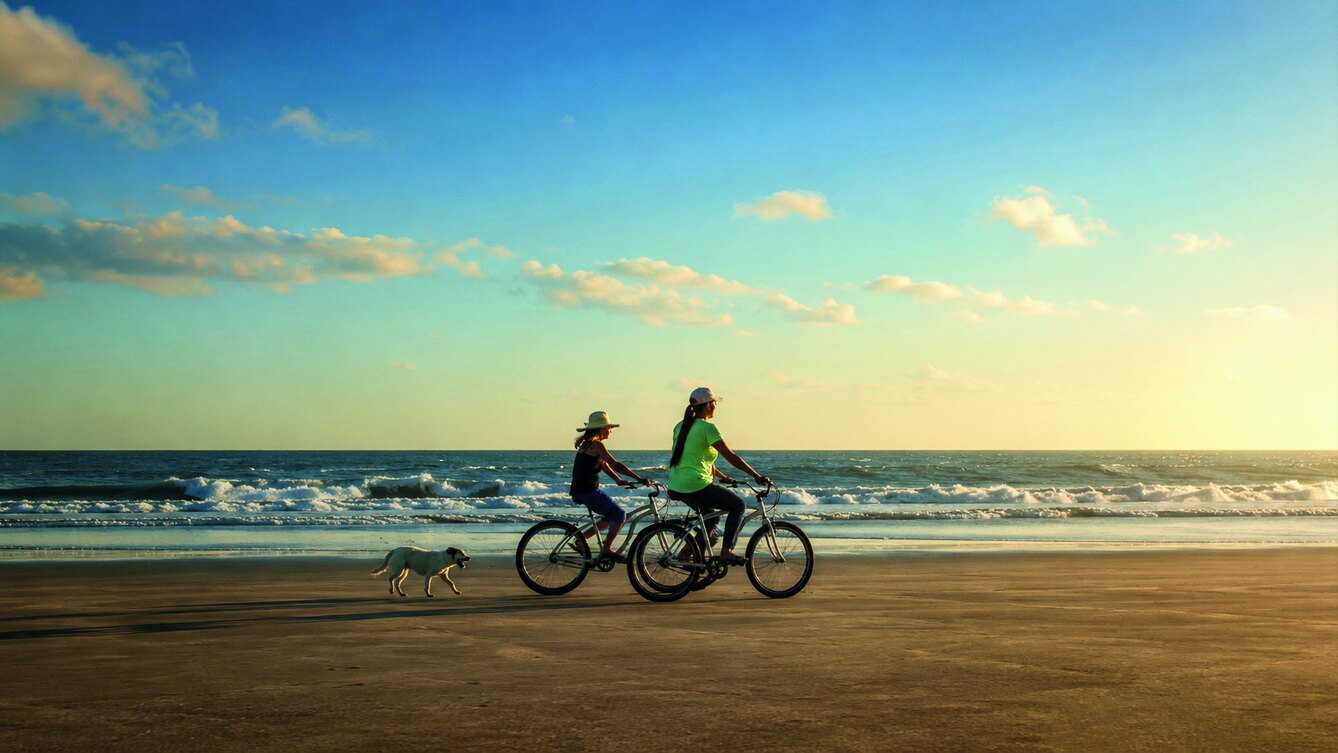 Ciclistas pedalando pela faixa de areia de Ilha Comprida ao amanhecer